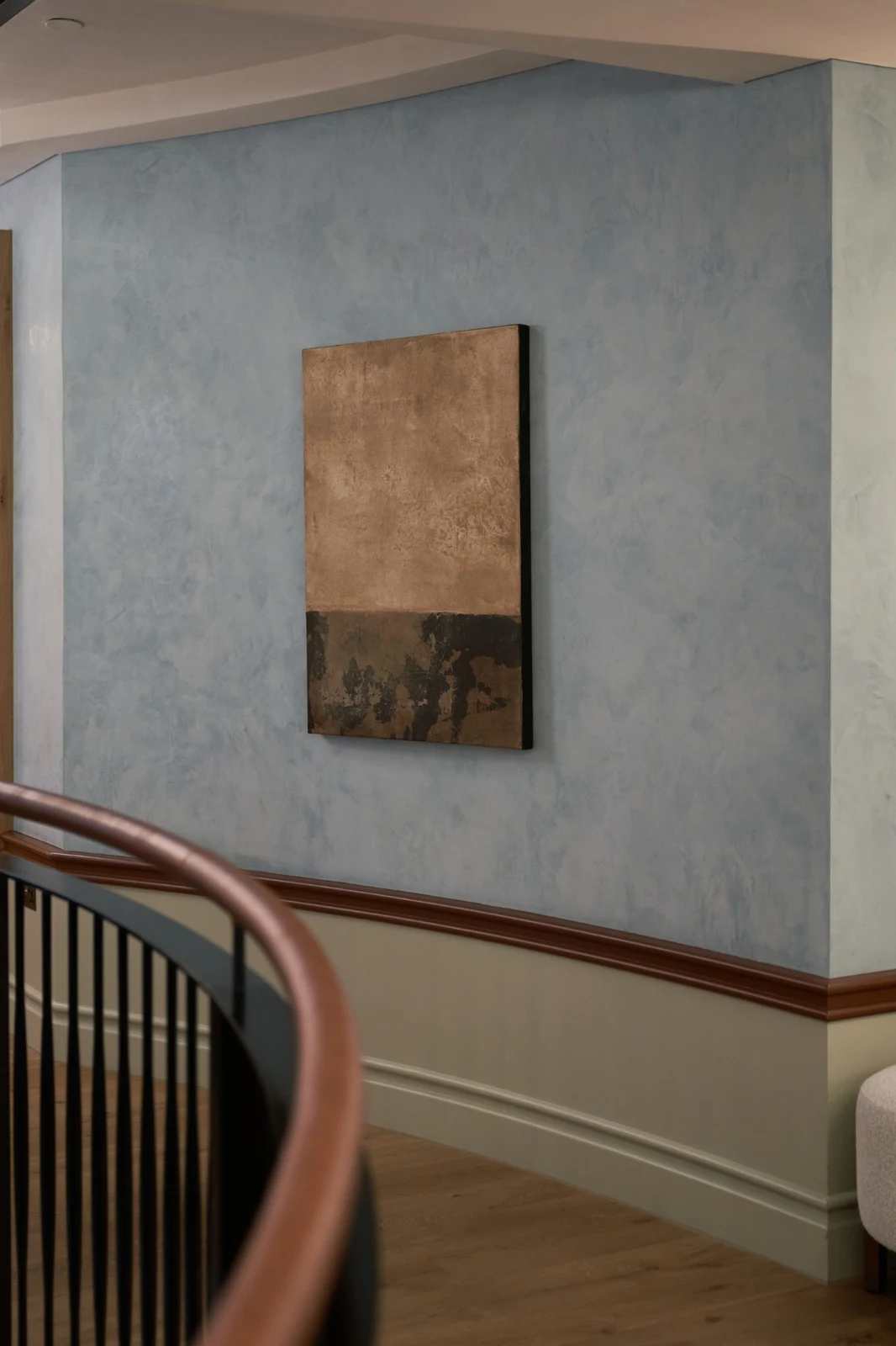 Untitled (GES#2) by Alexandra Yan Wong, hung on a blue plaster wall above a curved stair rail