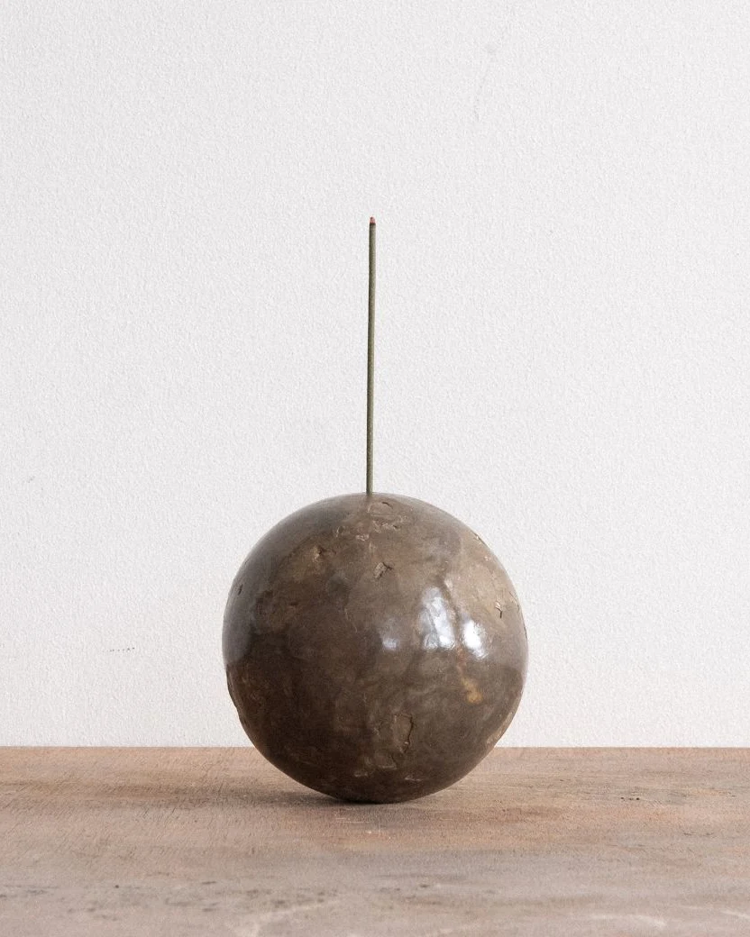 Incense Ball by Arran Gregory, a burnished clay sphere holding a single upright incense stick