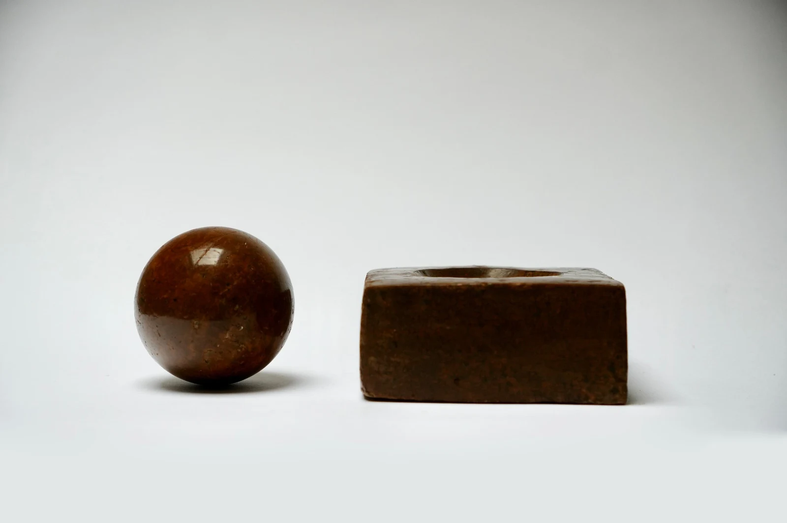 Dorodango Pair II by Edie Evans, the sphere and block seen from the side