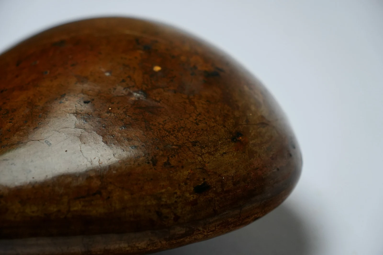 Ground by Edie Evans, close-up of its polished surface with a pale sheen