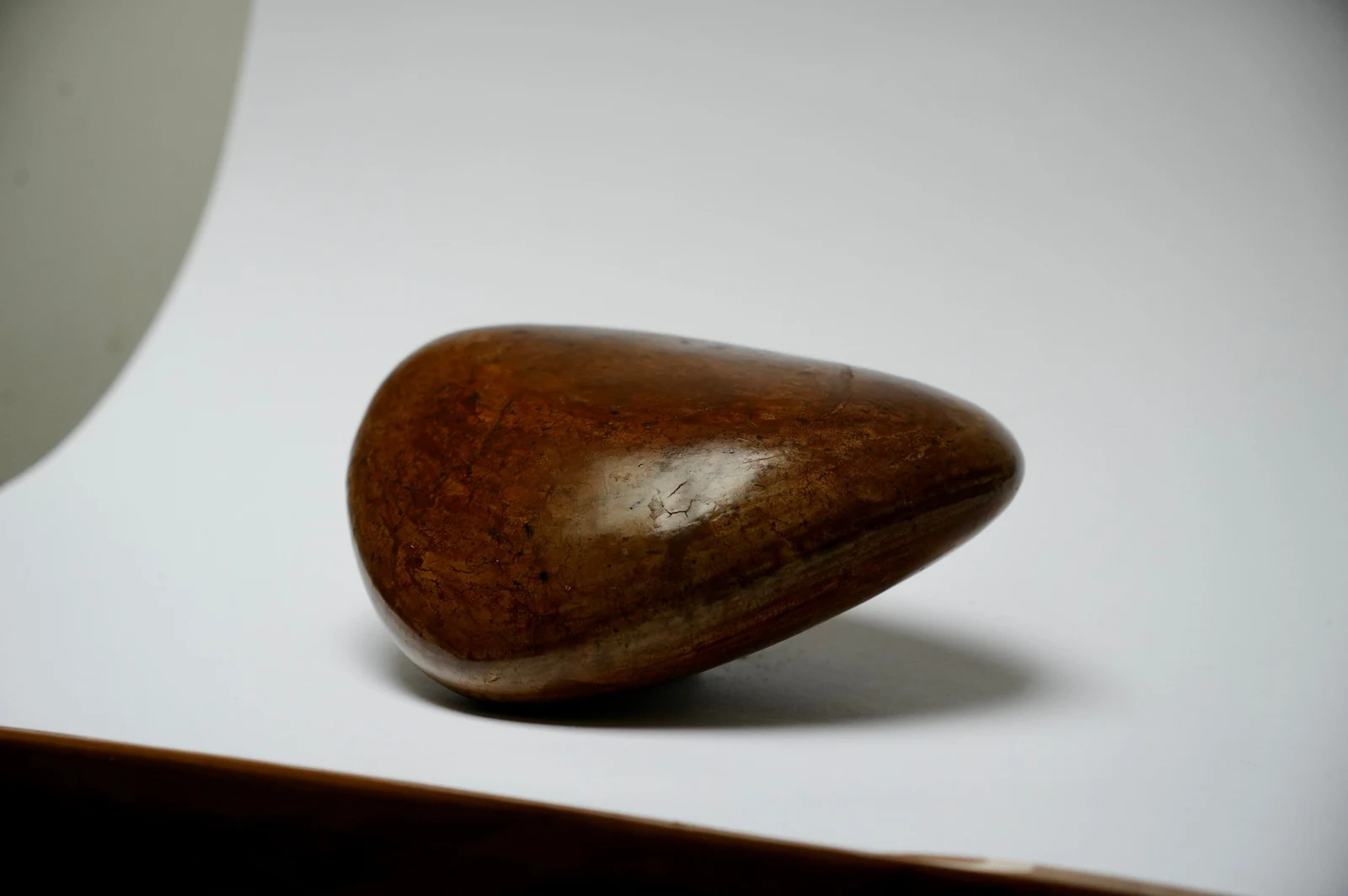 Ground by Edie Evans, a polished clay teardrop form resting on its side