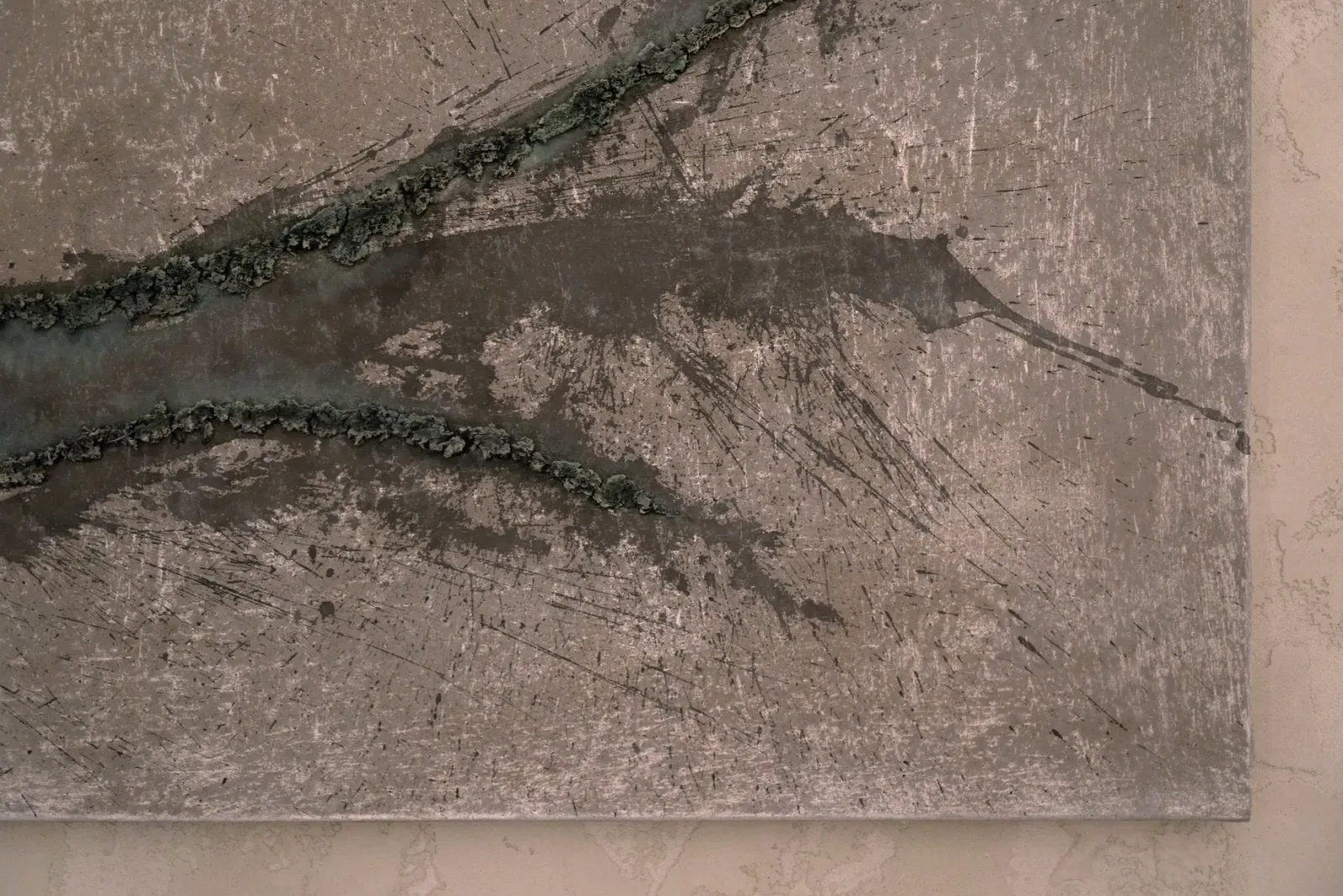 Lower right corner of Unearthing Series #2 by Eleanor Herbosch showing raised clay ridges, grey splashes and the canvas edge against a plaster wall