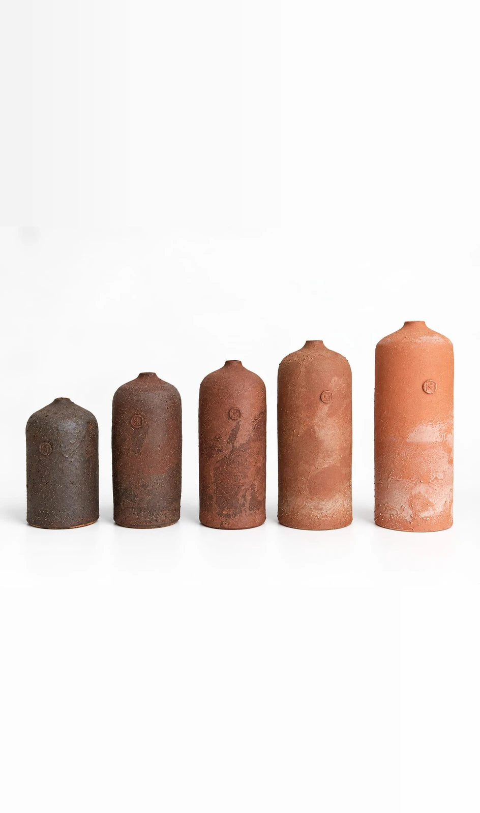 Bottle Series by Jacob Chan, five unglazed London Clay bottles rising in height from dark brown to pale terracotta