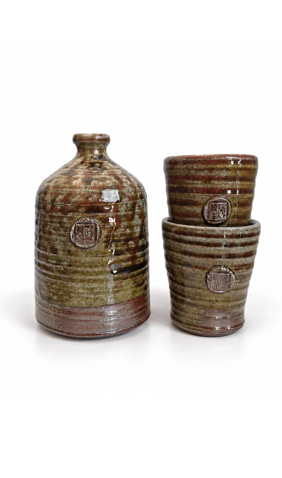 Sake Set #2 by Jacob Chan, a round-shouldered green and rust soda-fired bottle beside two stacked ribbed cups