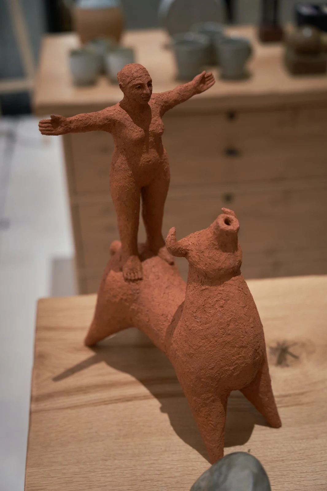 Beauty and the Beast by Zahed Tajeddin, seen from the front on a wooden table, the figure's arms outstretched